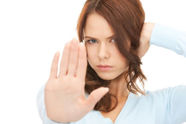 Woman with one hand one her ear and the other out to say stop