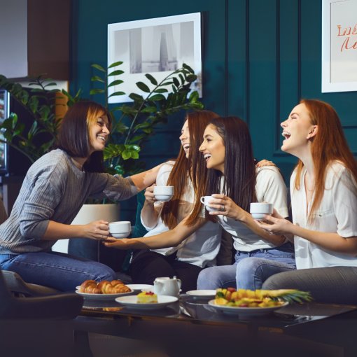 four women together enjoying coffee and laughing together. The Resilient Stepmom Blueprint support group